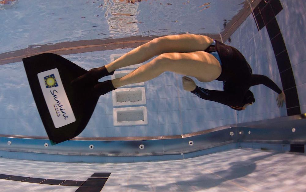 Freediver with monofin turning in the pool